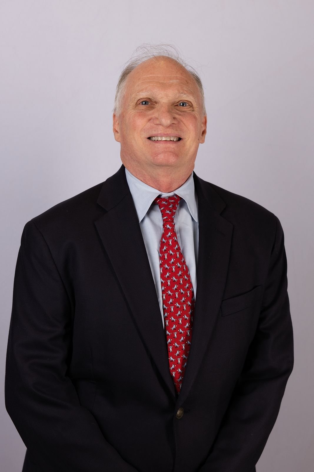 Skip York in a navy suit, studio portrait